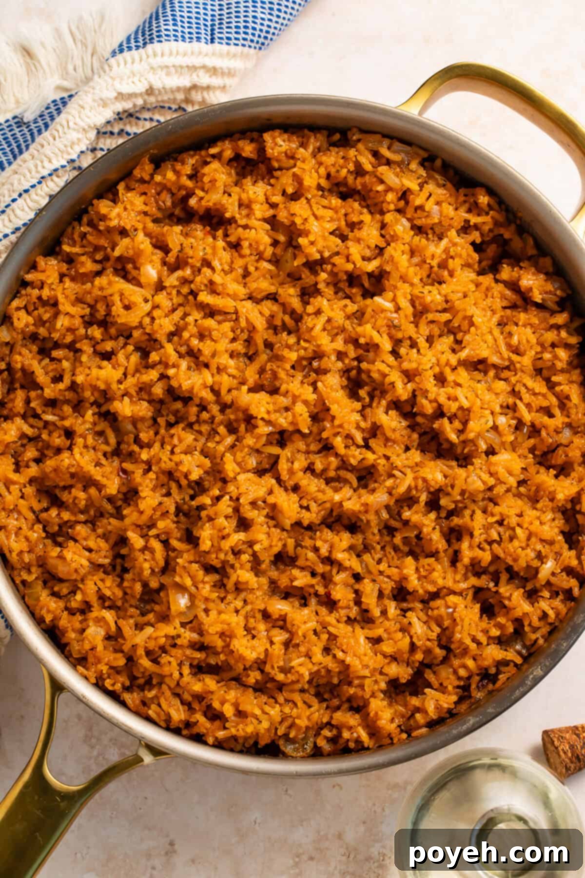 Texas Roadhouse Style Rice 3 Pan of seasoned rice with a blue and white kitchen towel on one side.